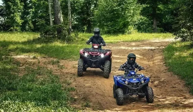 Two Yamaha ATVs on a trail